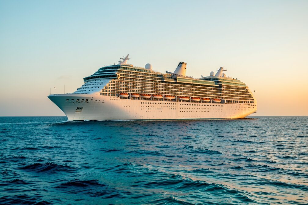 A cruise ship under way on open water off Great Stirrup Cay in the Bahamas, late afternoon November sunlight catching its hull beneath a clear autumn sky